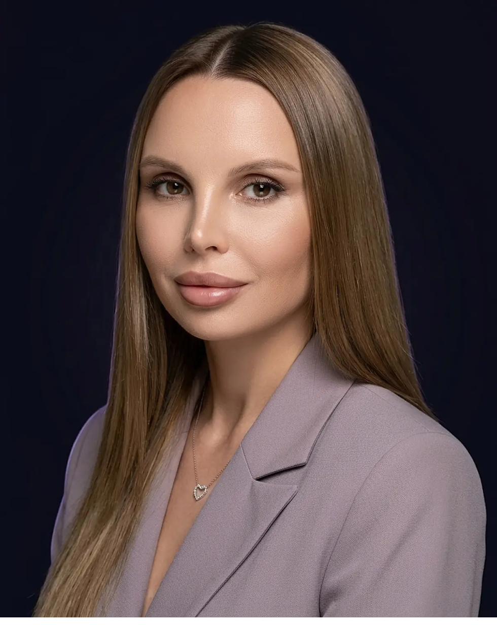 Марина Головина — фотограф-портретист, крупный план в лавандовом пиджаке и с кулоном-сердцем на тёмном фоне